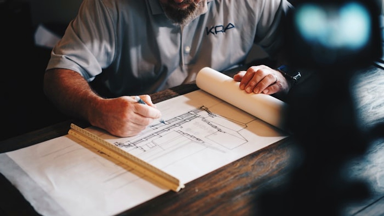 Architecture drafting table, blueprints and modern building model